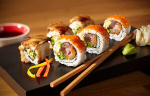 a plate of sushi with chopsticks